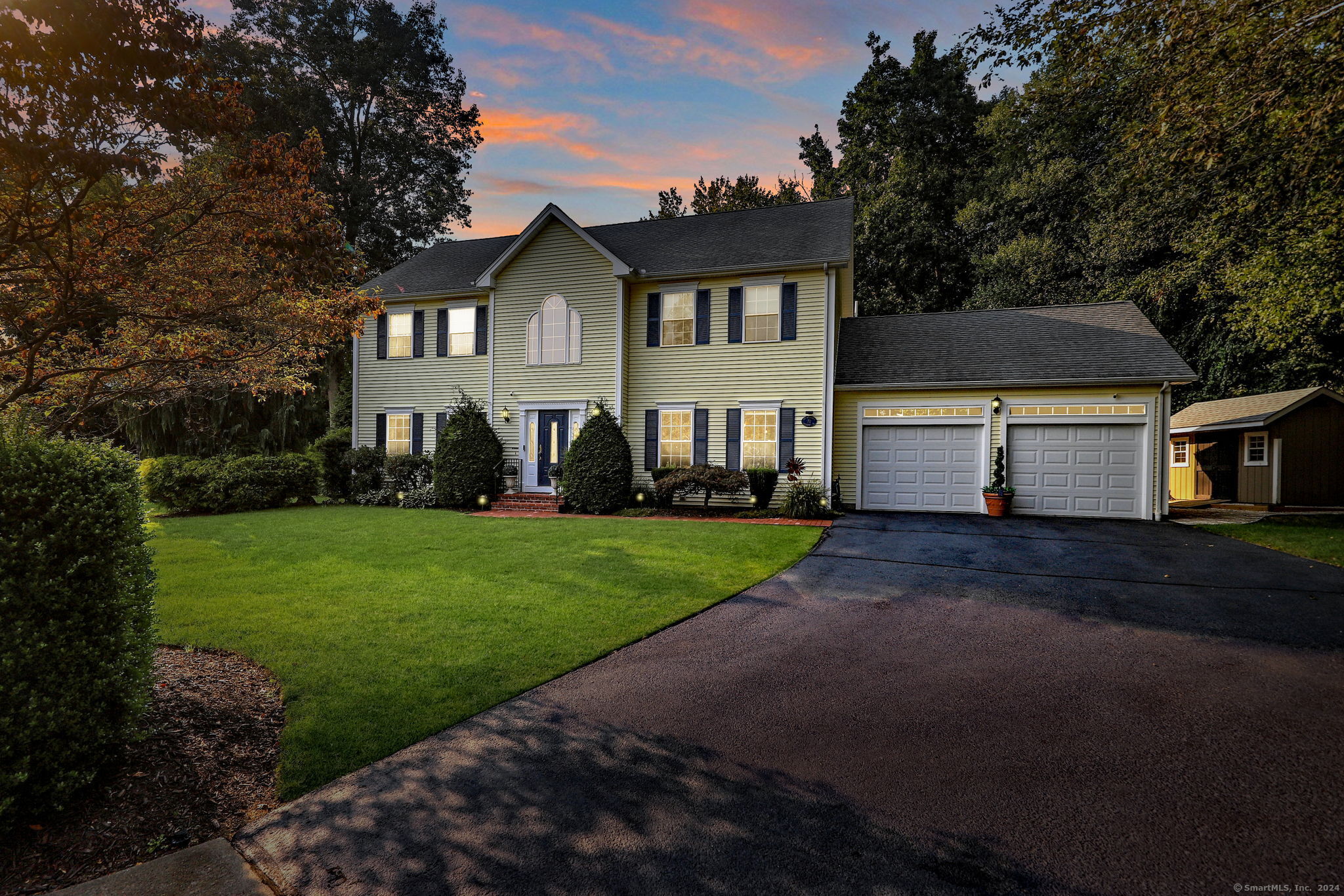 a front view of a house with a yard and trees