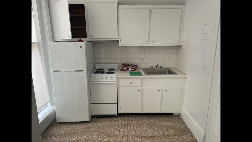 a kitchen with white cabinets and white appliances