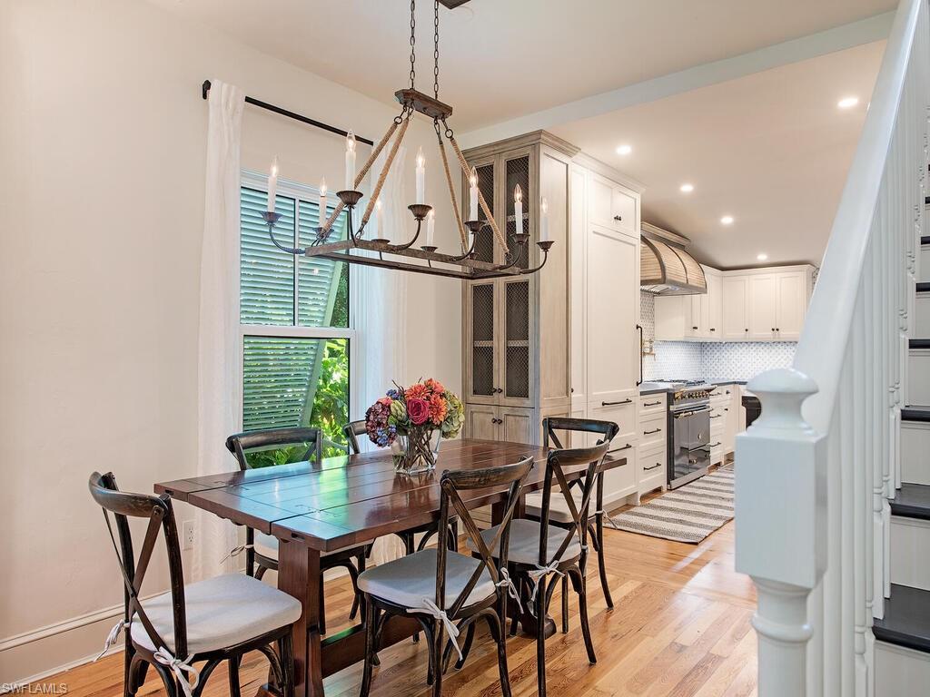 a view of a dining room and livingroom with furniture wooden floor a chandelier