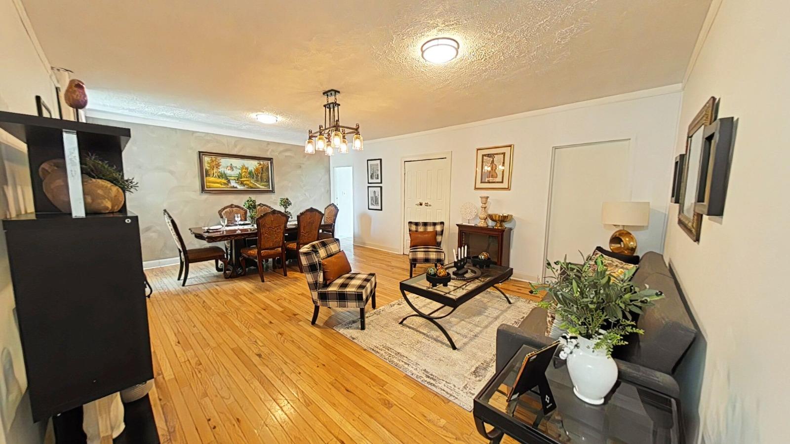 a living room with furniture a chandelier and a flat screen tv