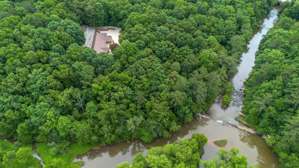 an aerial view of a house with a yard and lake view