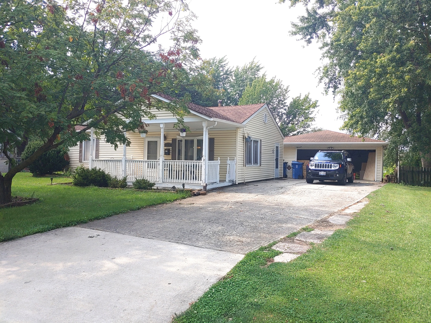 a front view of a house with a garden and trees