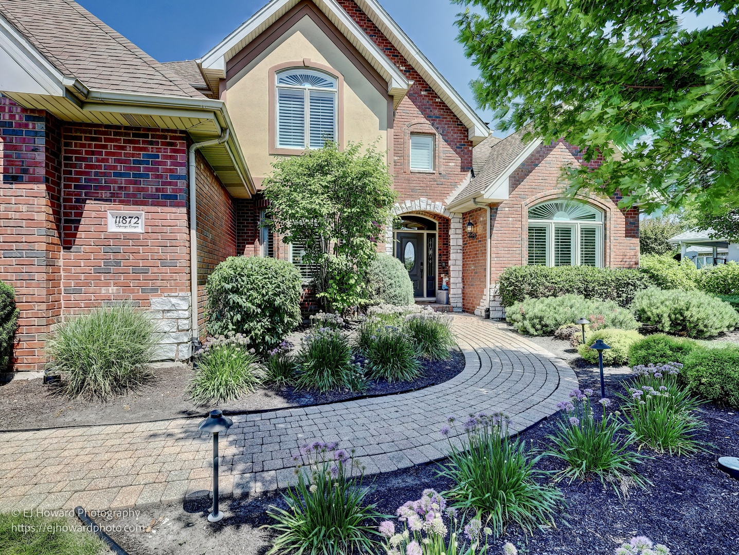 a front view of a house with a yard and potted plants