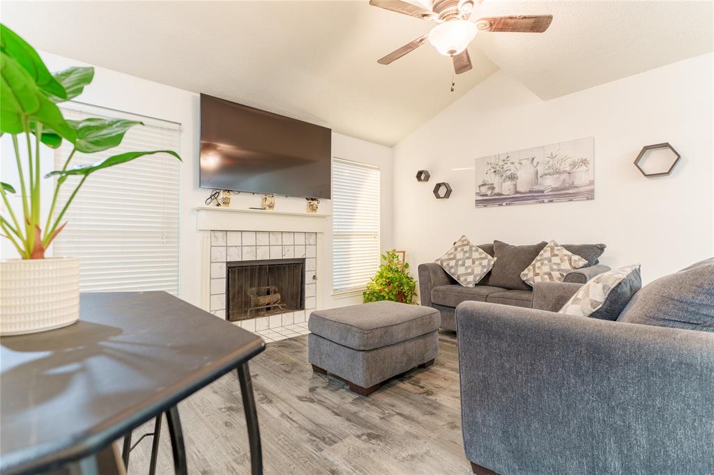 a living room with furniture a flat screen tv and a fireplace