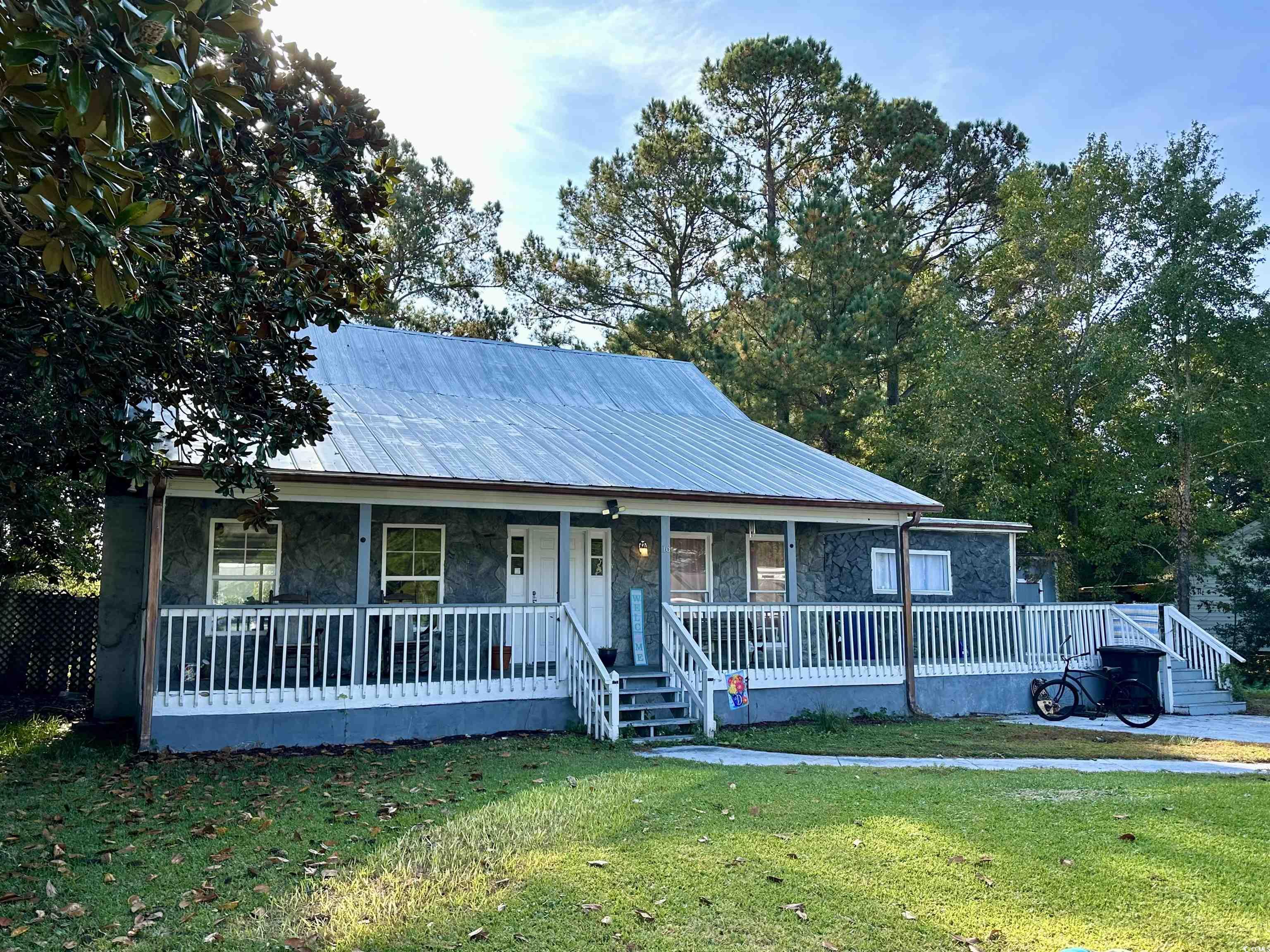 View of front facade with a front lawn and covered