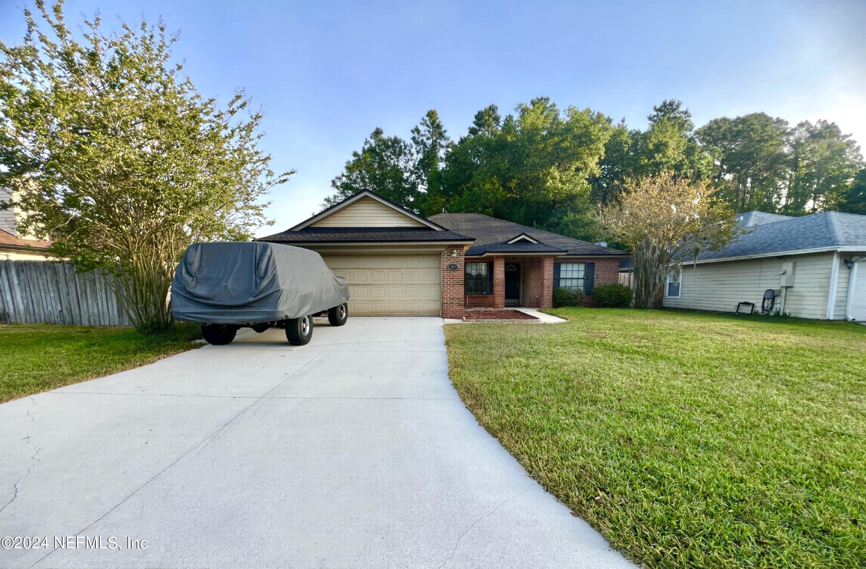 a front view of a house with a garden and yard