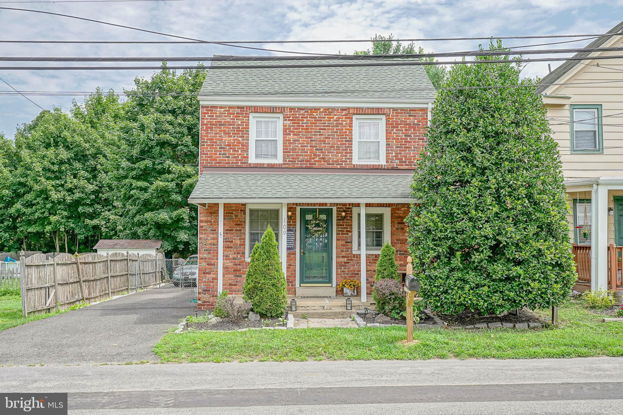 a front view of a house with a garden and plants