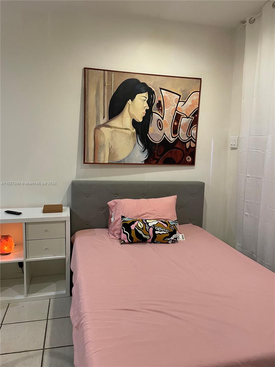 a bedroom with a bed and painting on the wall