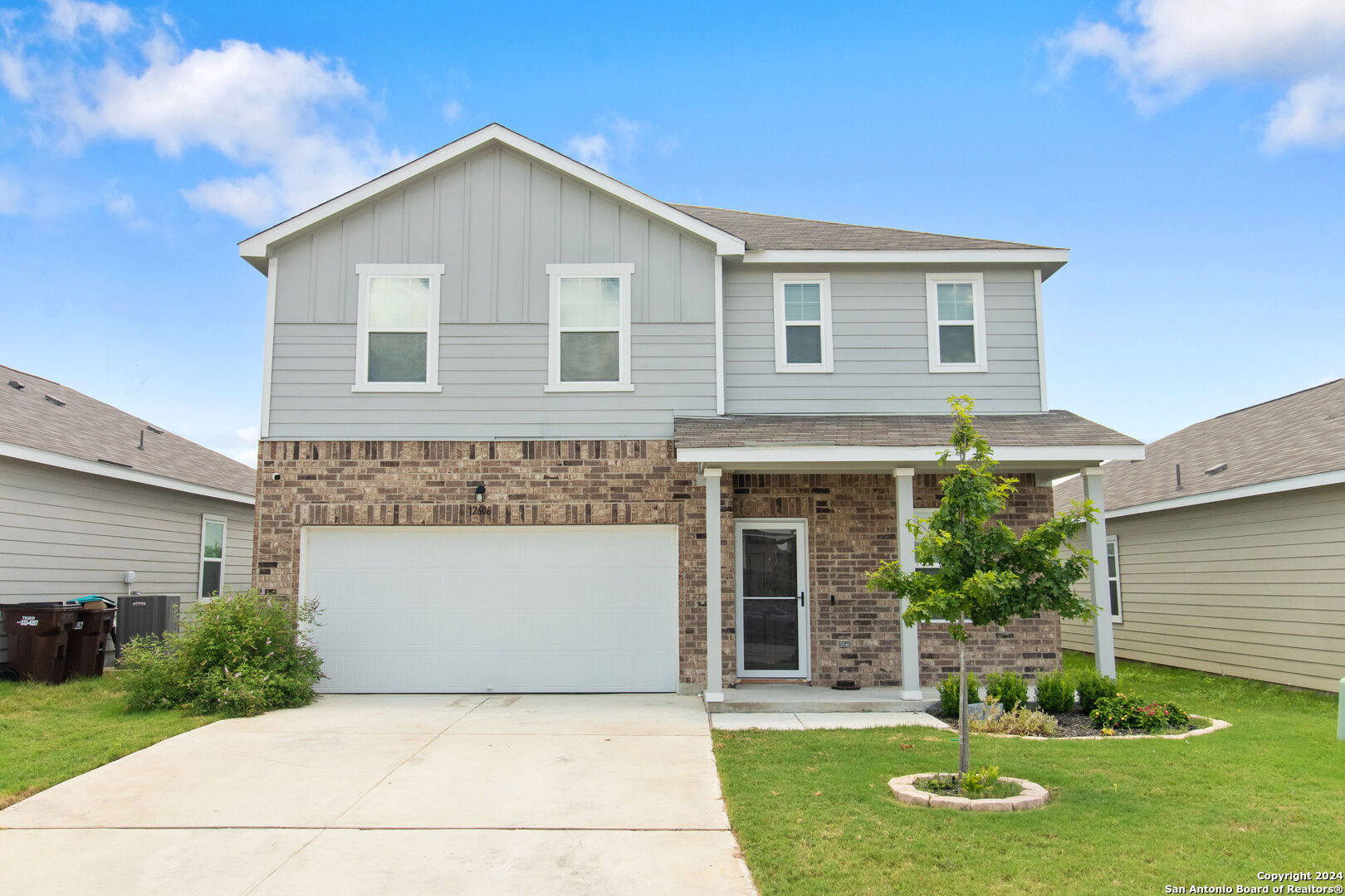 a front view of a house with a yard and garage