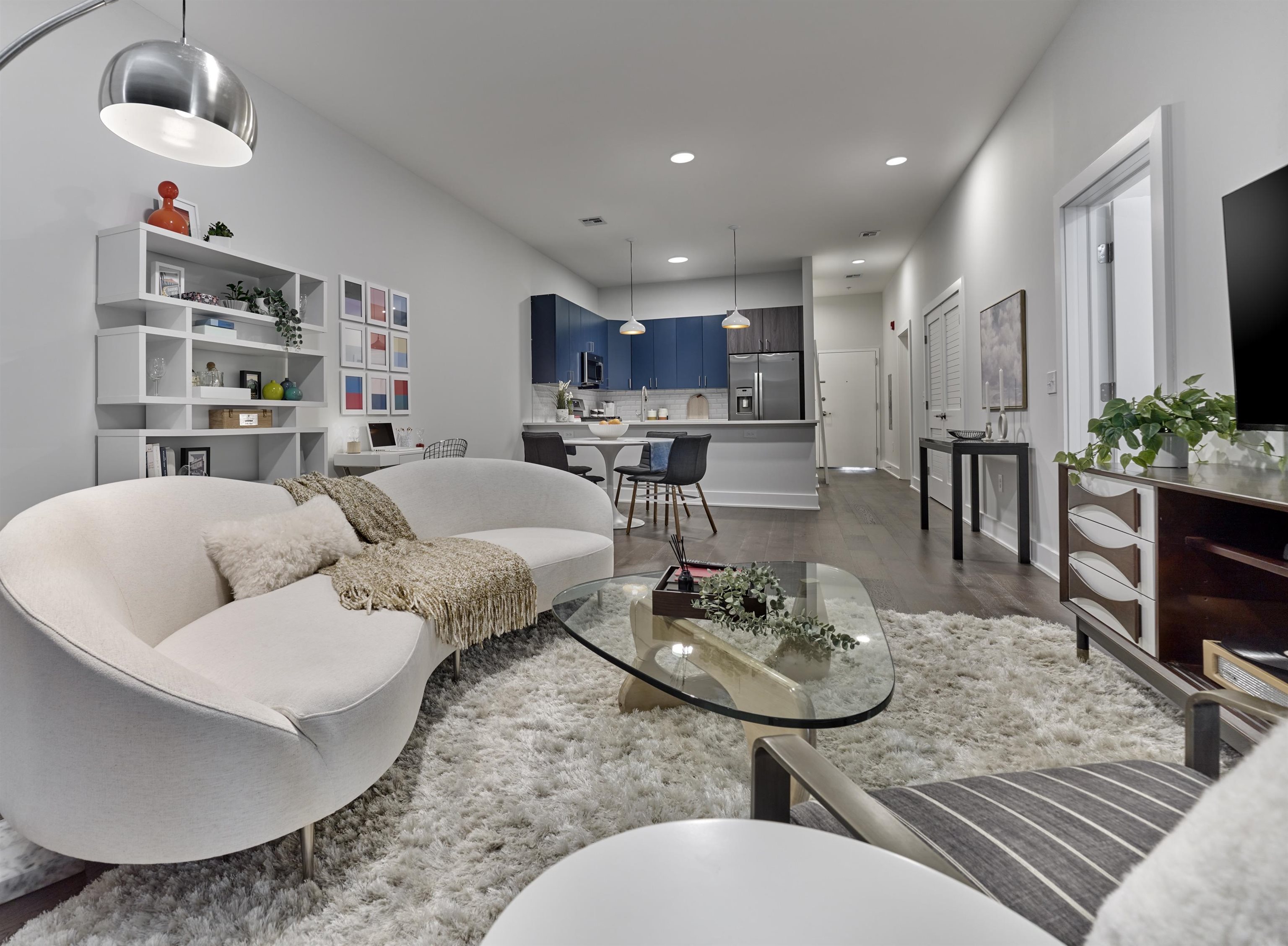 a living room with furniture kitchen and a table