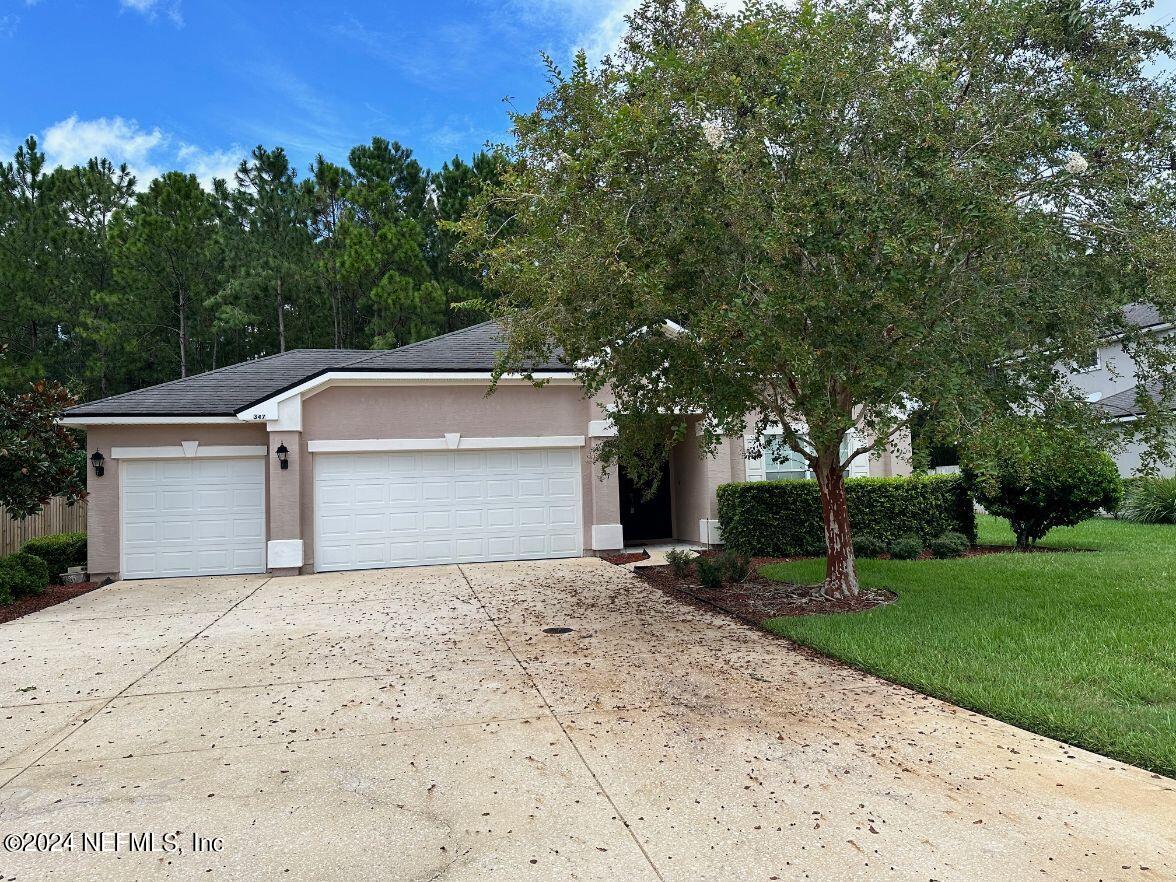 a view of a house with a yard and garage