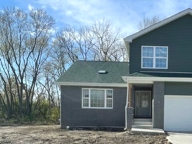 a view of a house with a yard and large tree