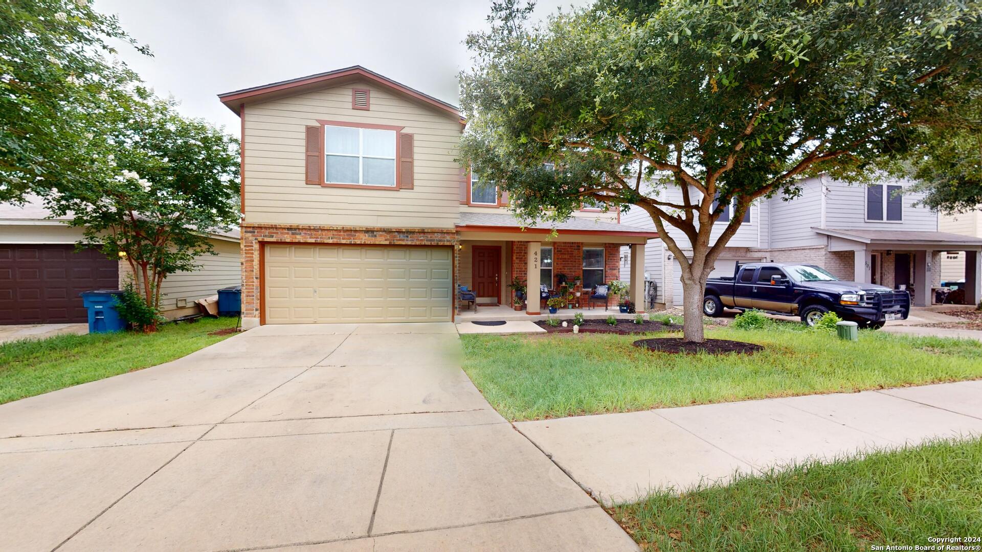 a front view of a house with a yard and trees