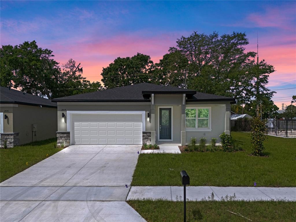 a front view of a house with a yard and trees