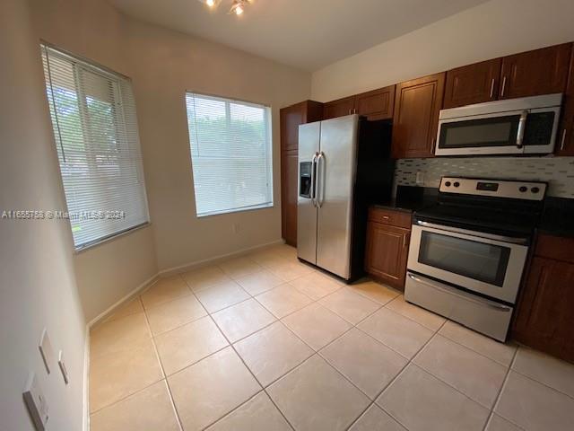 a kitchen with stainless steel appliances a refrigerator and a stove top oven