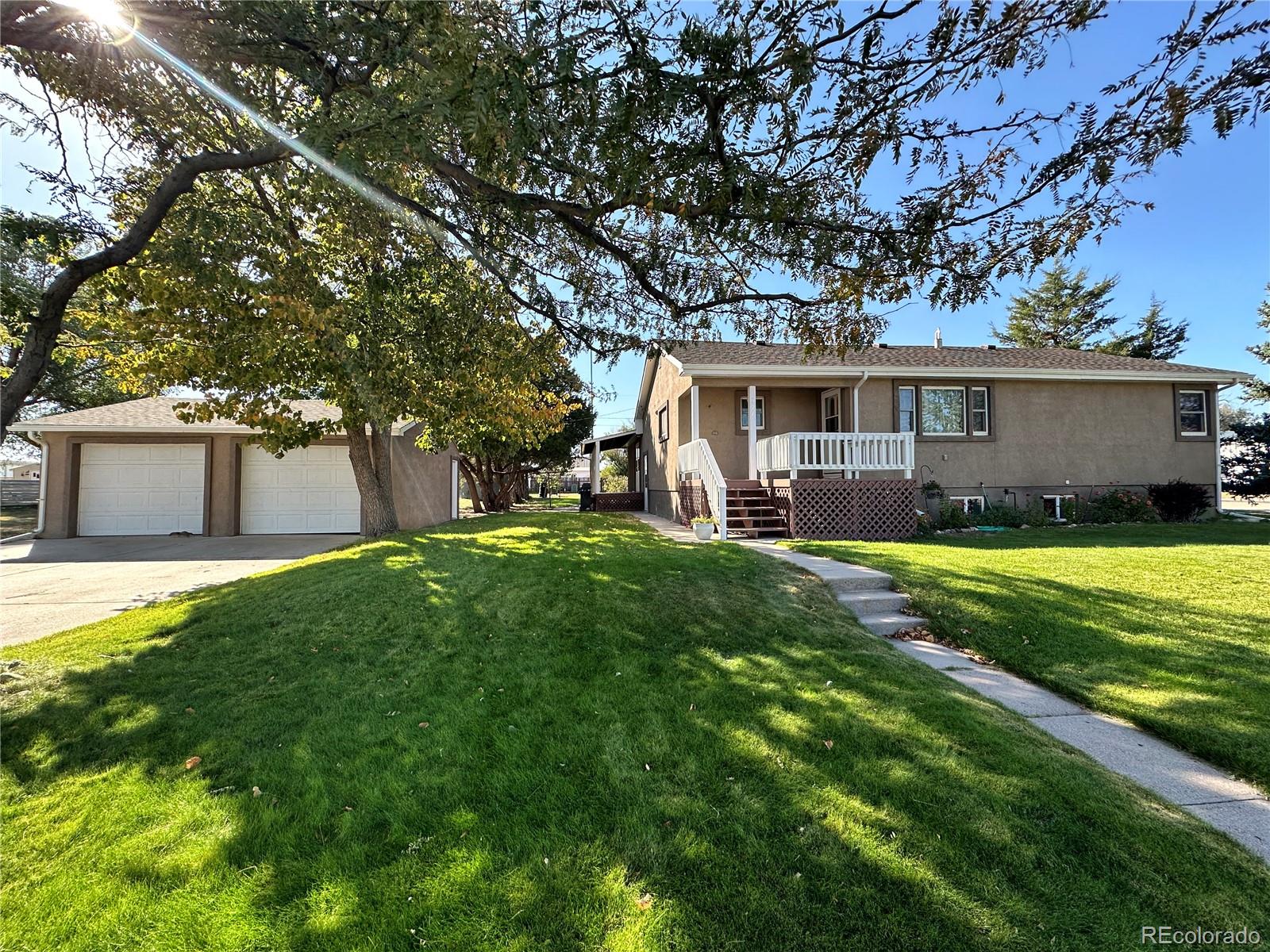 a view of a house with backyard and a tree