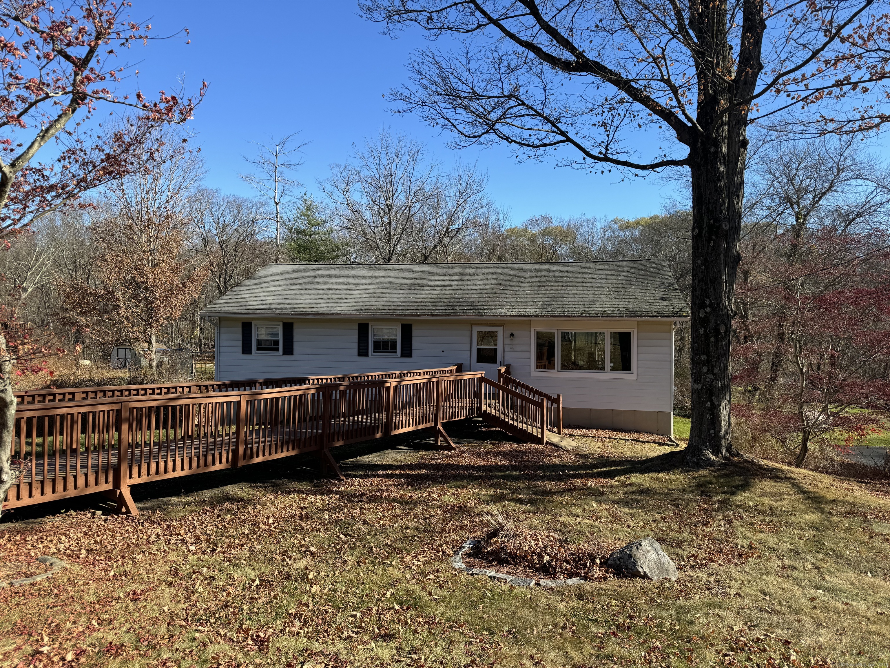 a view of a house with wooden fence next to a yard