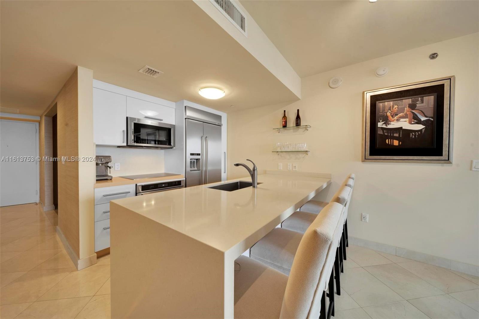 a open kitchen with stainless steel appliances a stove refrigerator sink and microwave