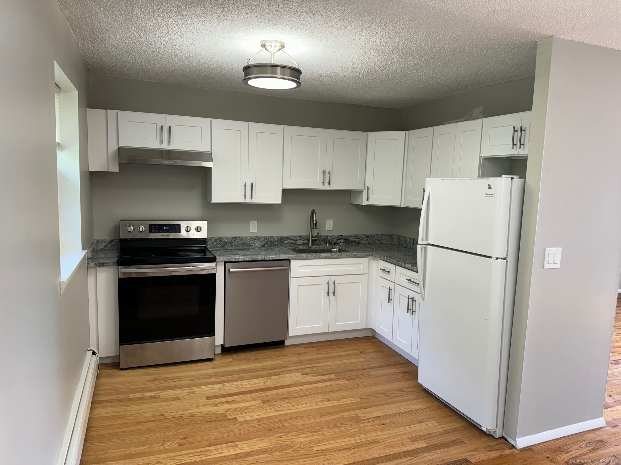 a kitchen with a refrigerator stove and white cabinets