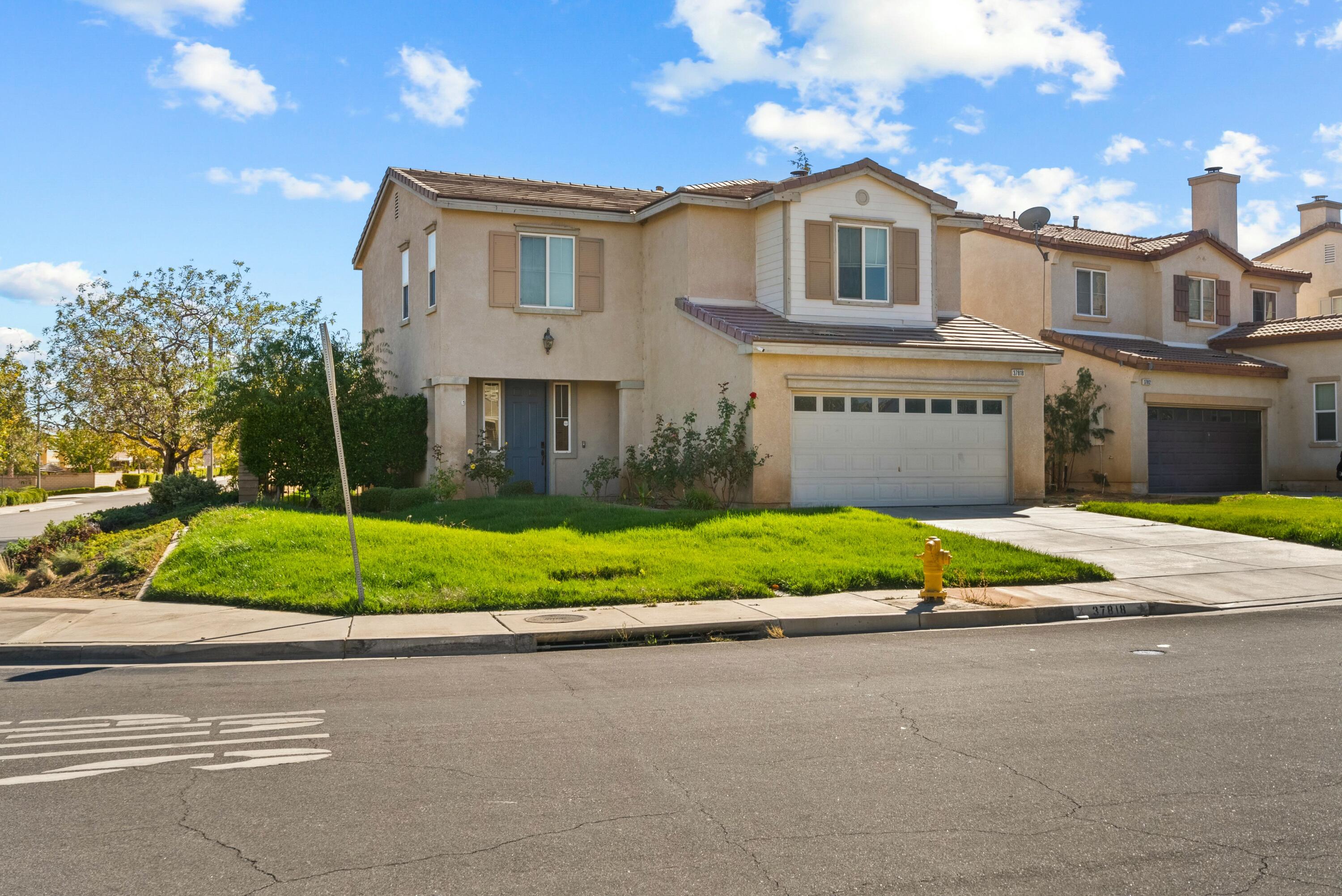 a front view of a house with a yard and potted plants