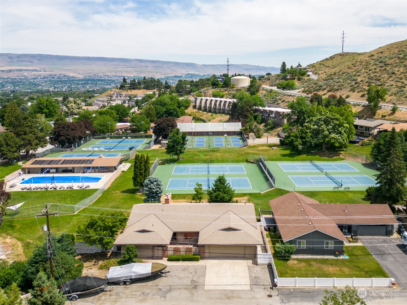 an aerial view of residential houses with outdoor space and swimming pool