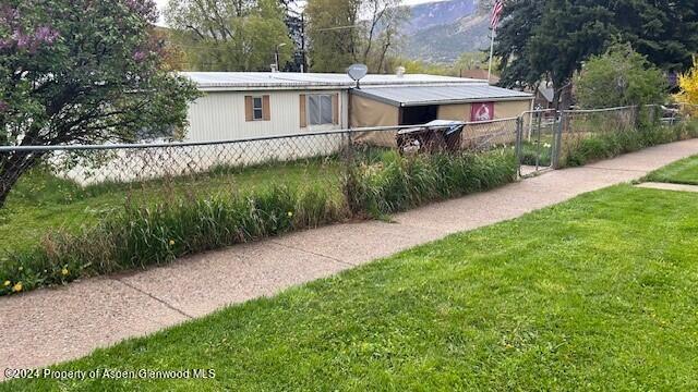 a view of a small house with a yard and sitting area