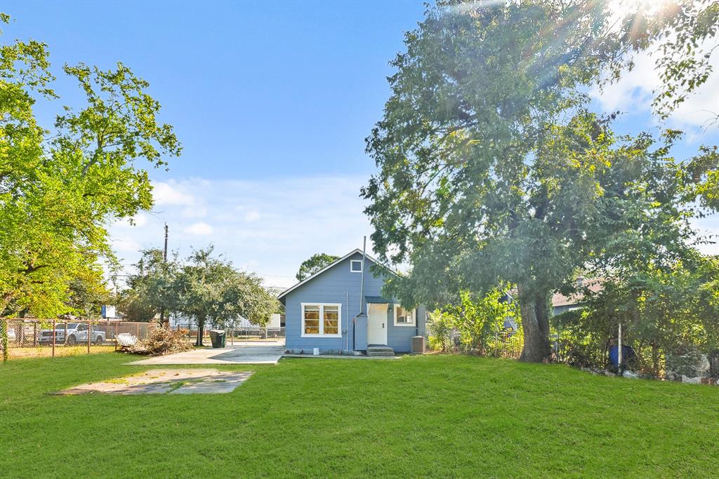 a front view of a house with a garden and trees