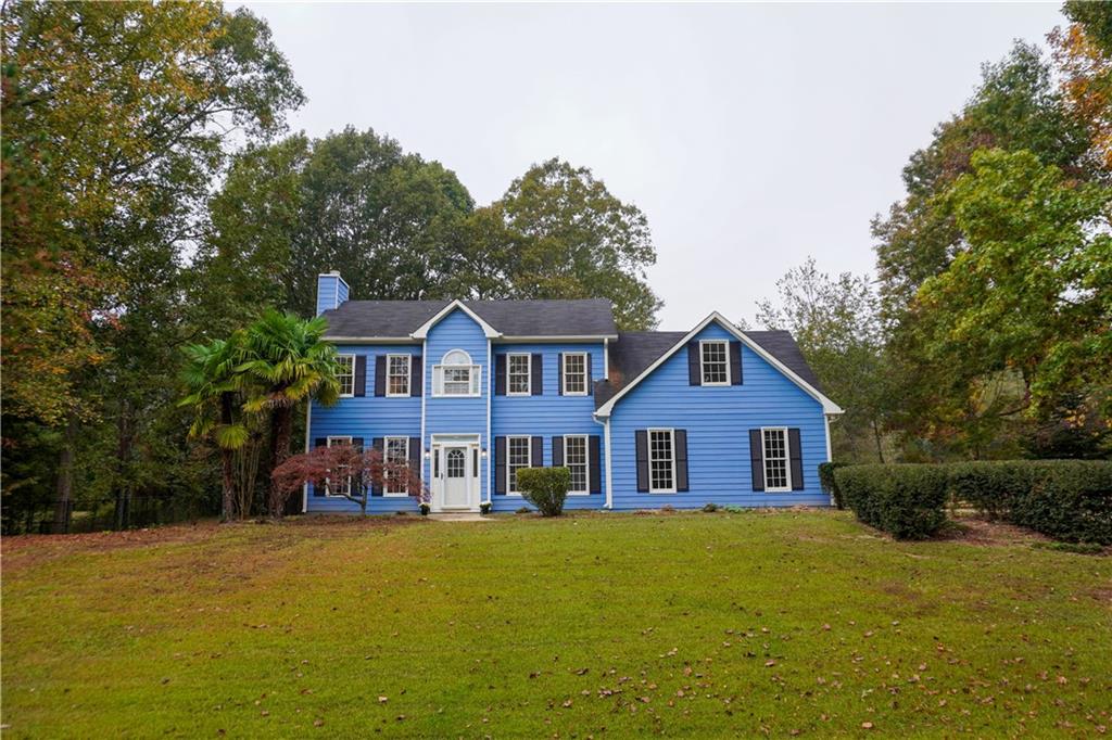 a front view of a house with yard and green space