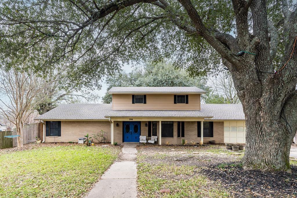 a view of a yard in front of a house with large tree