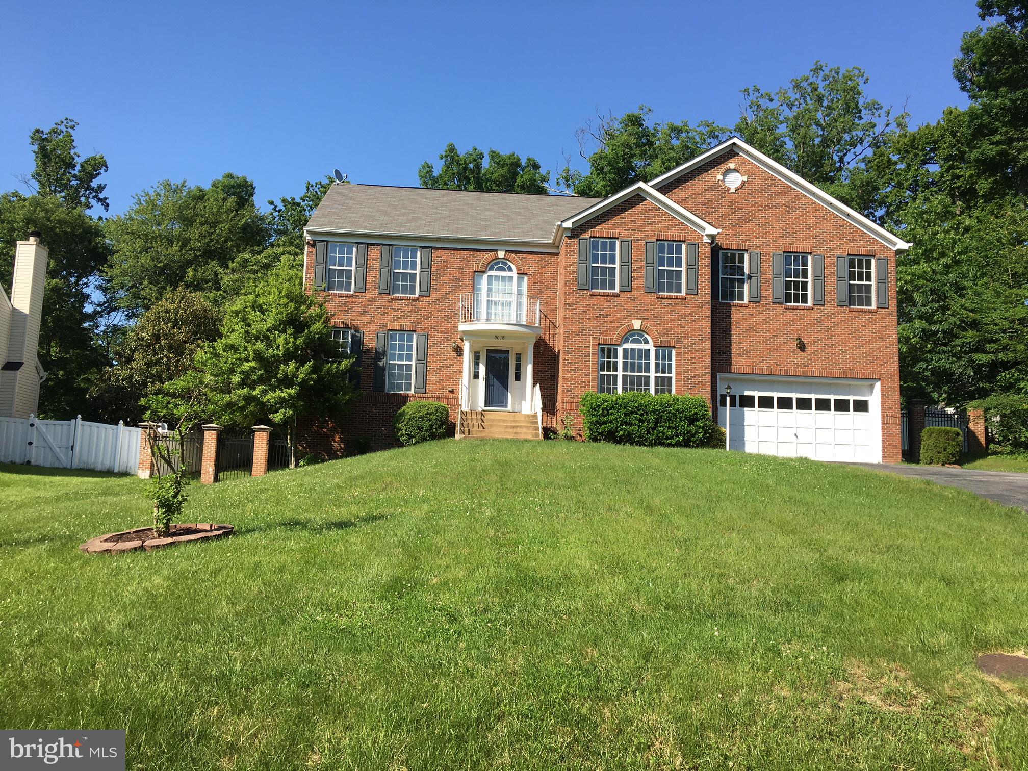 a front view of a house with a yard and green space