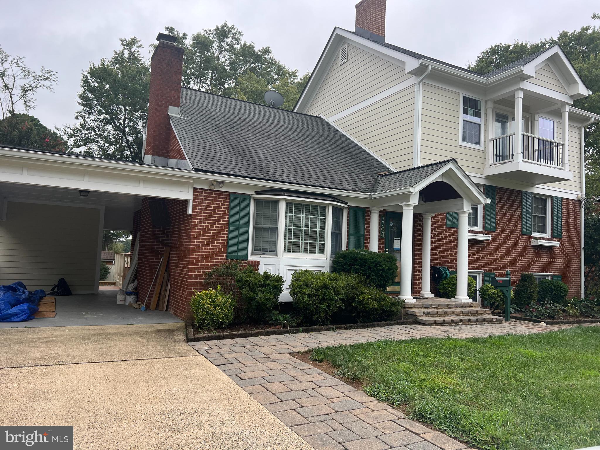 a front view of a house with a yard and potted plants