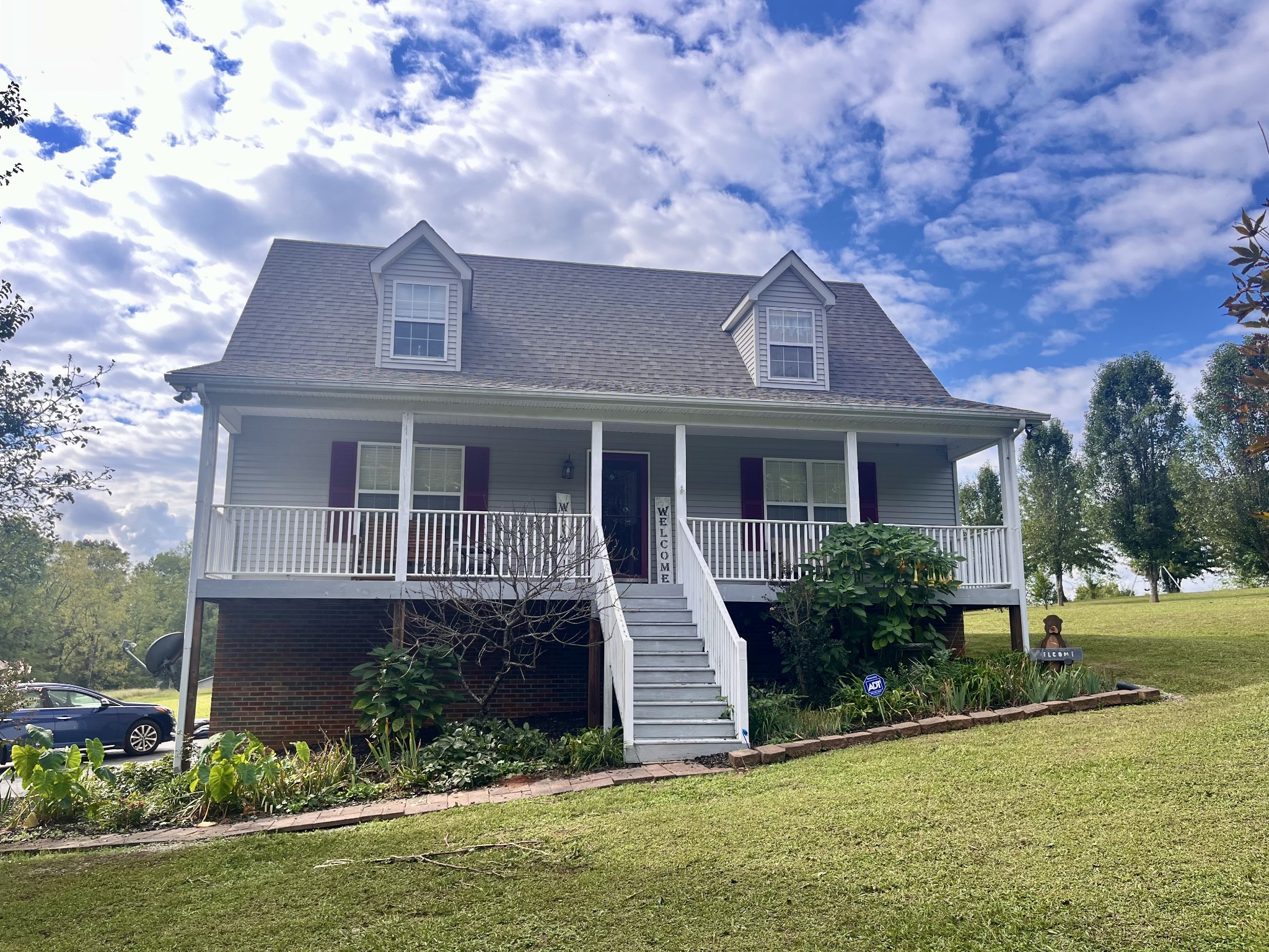 a front view of a house with a yard and potted plants