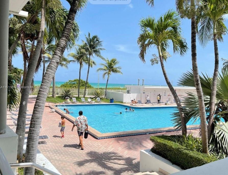 a view of a swimming pool with a garden and patio