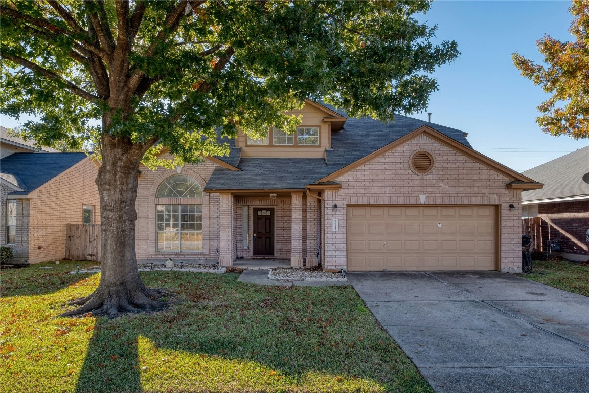 a front view of house with yard and trees in the background