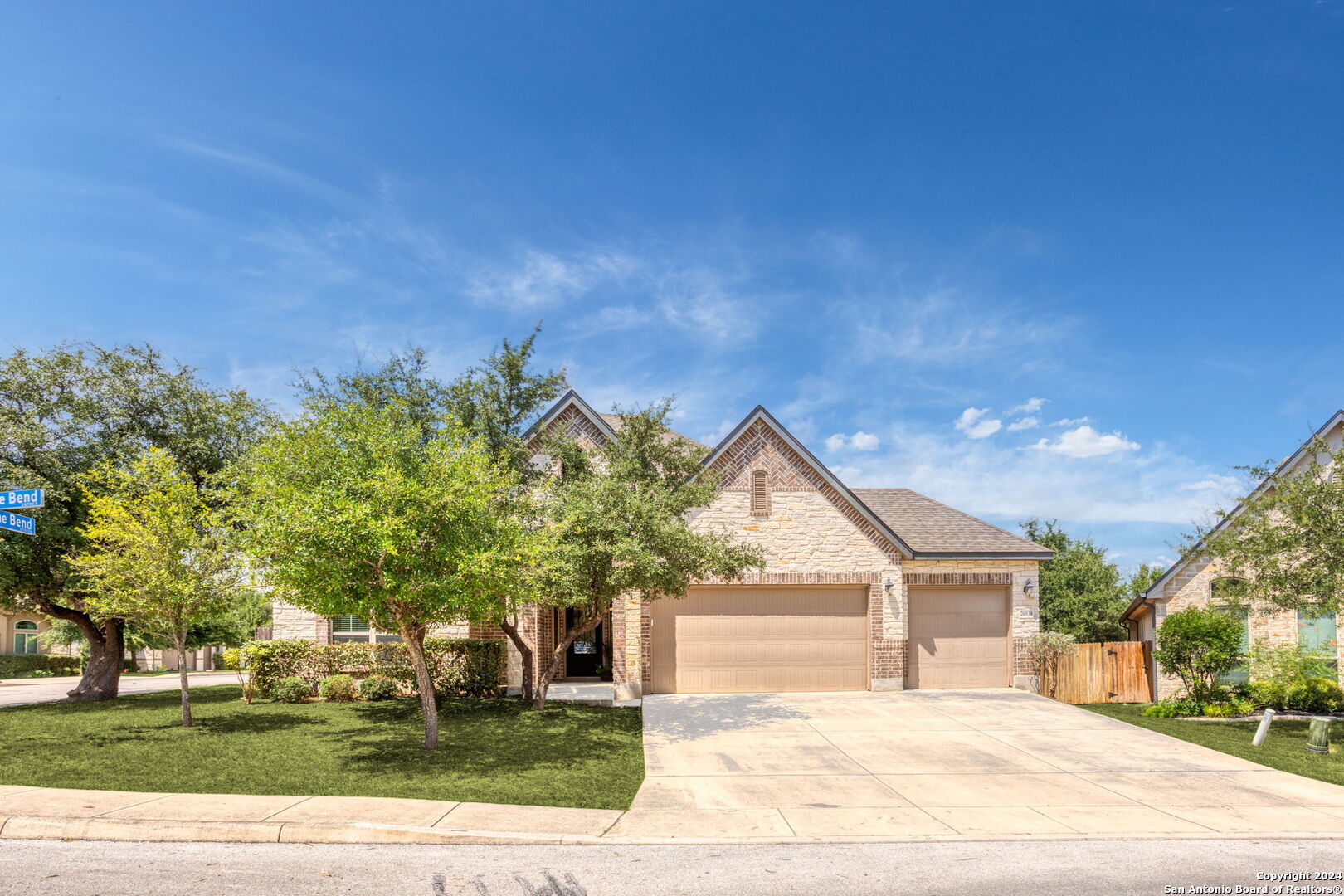 a front view of a house with a yard and trees