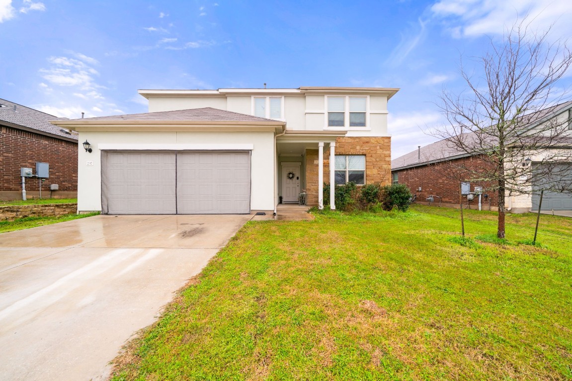 a front view of a house with a yard and garage