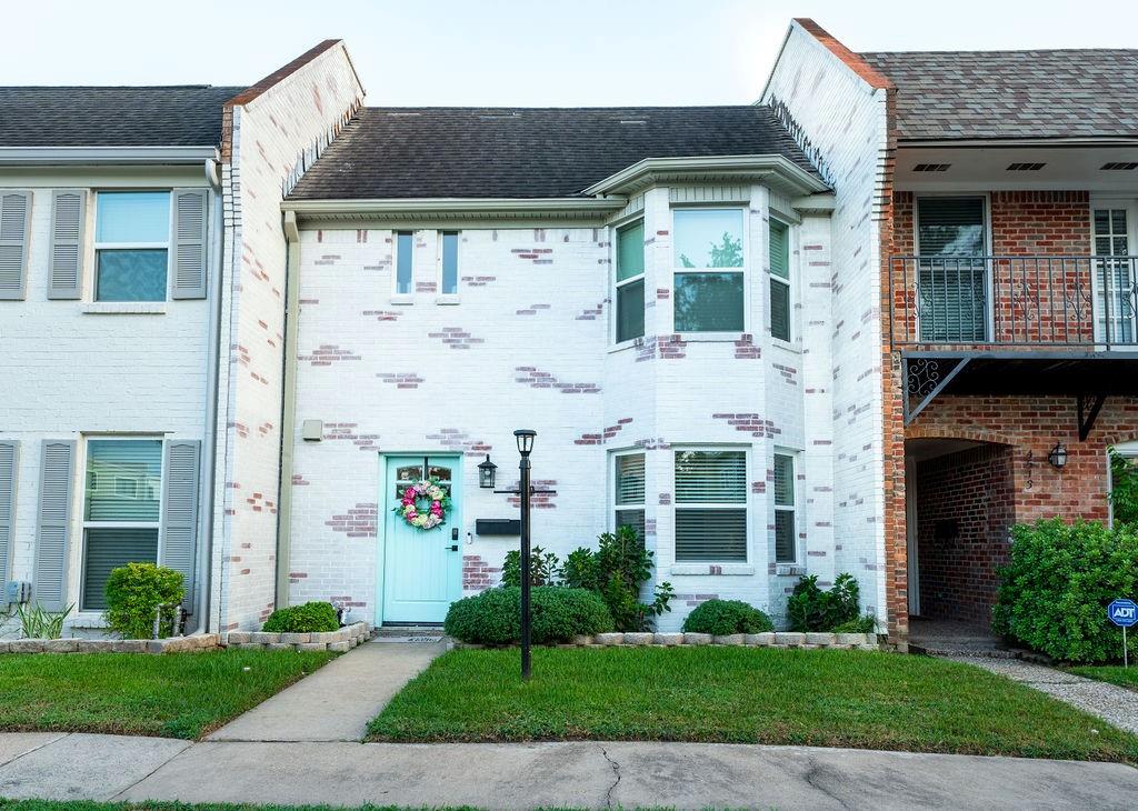 a front view of a brick house with a yard