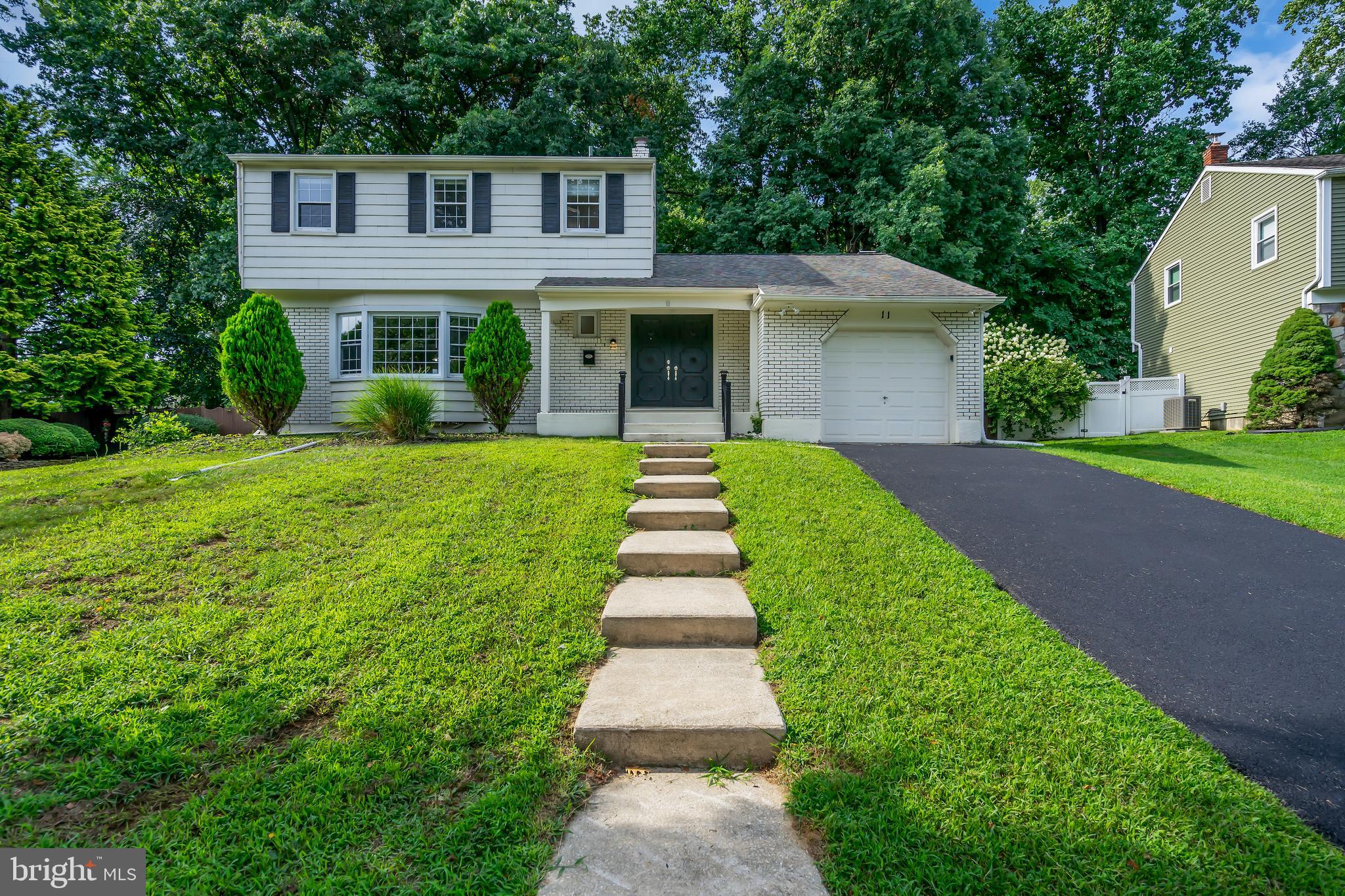 a front view of a house with a yard and potted plants