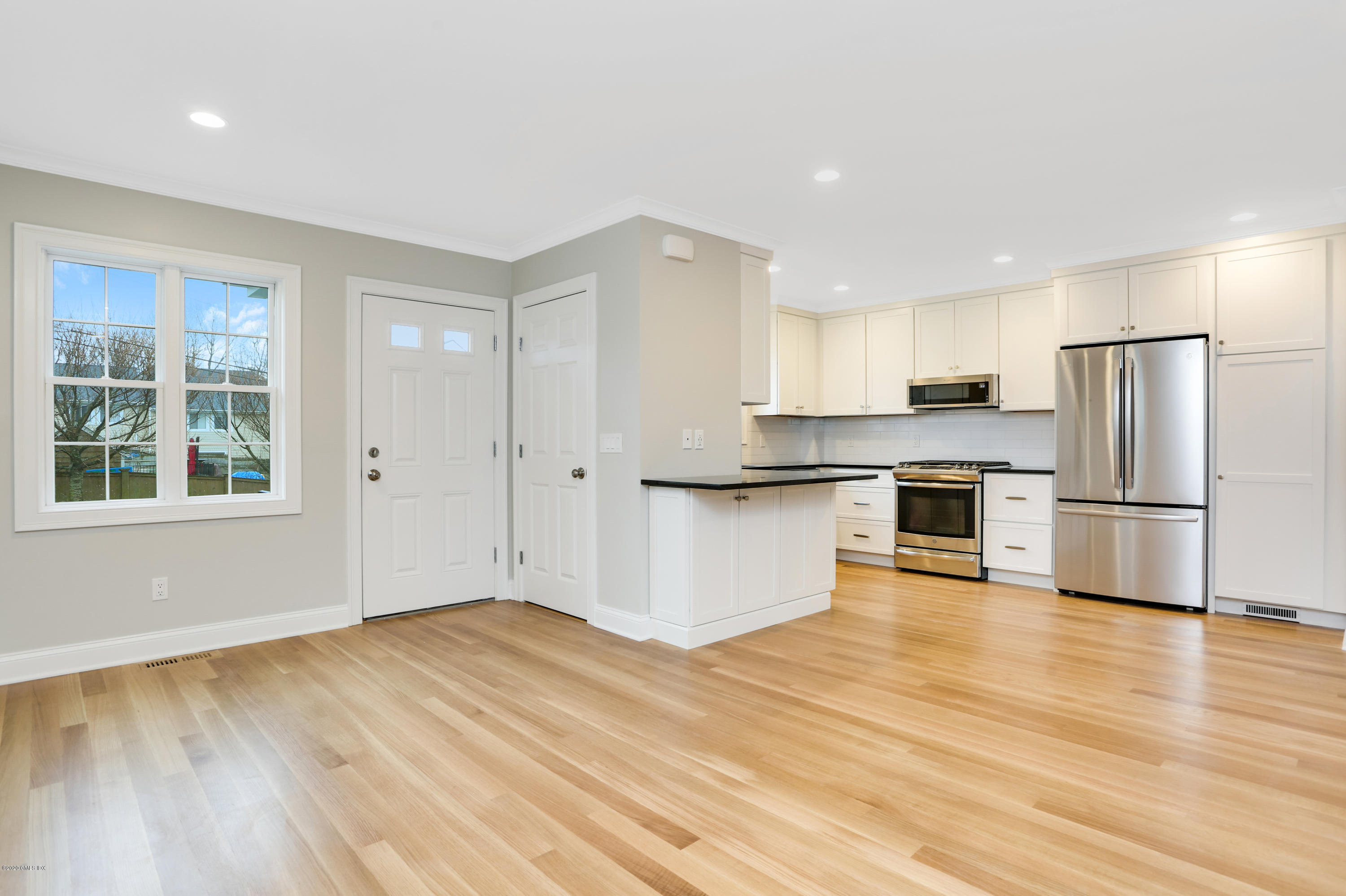 a kitchen with granite countertop a refrigerator and a stove top oven