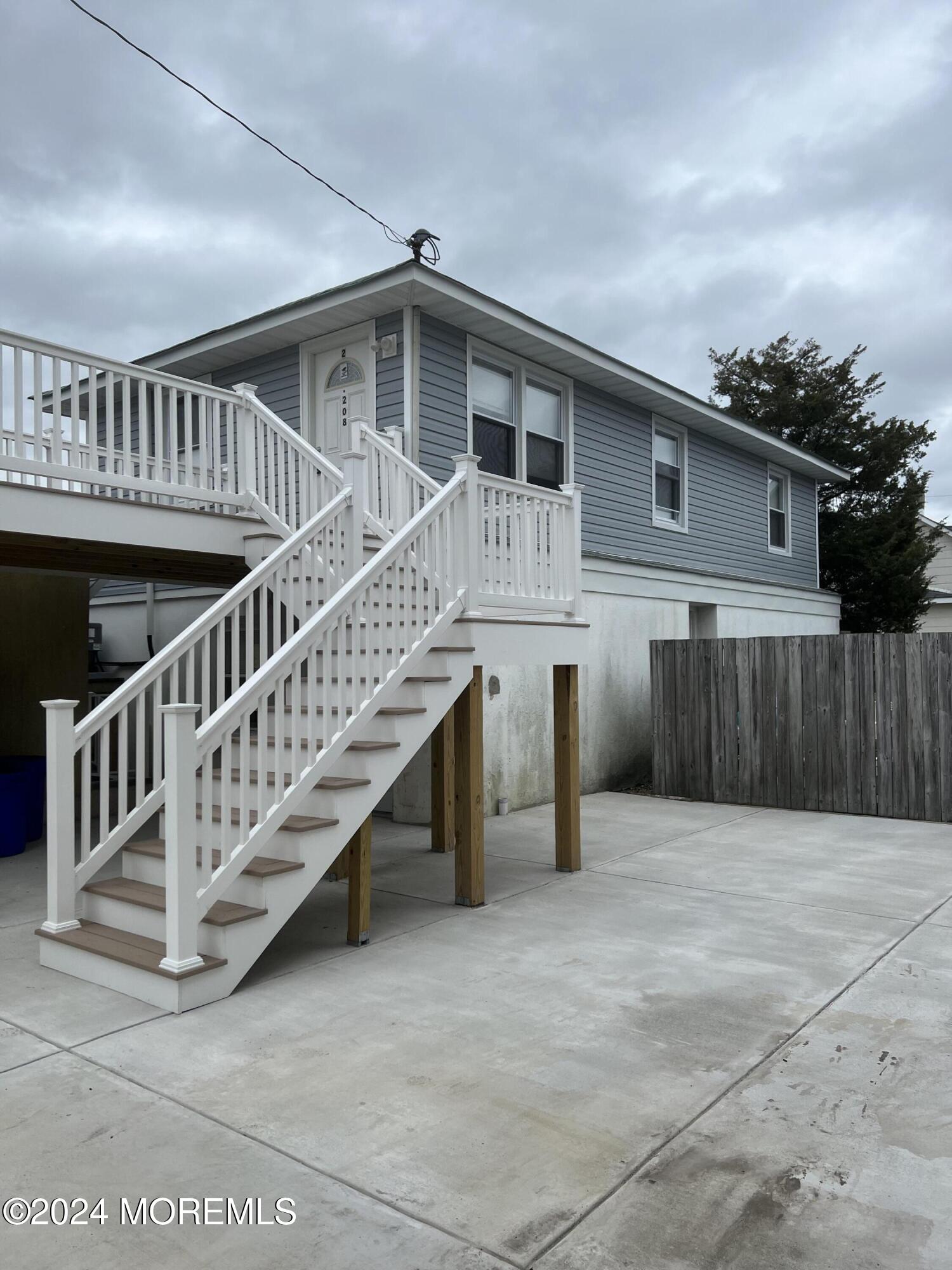 a view of a house with wooden deck and a floor to ceiling window