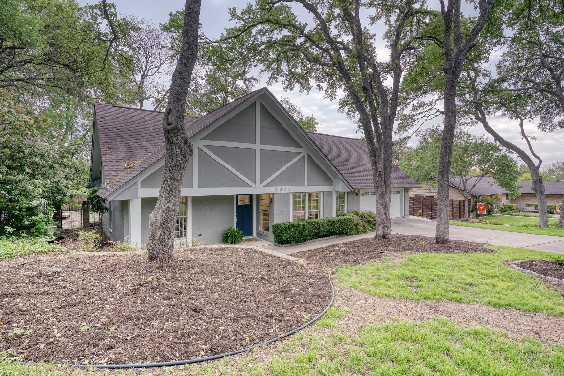 a front view of a house with a yard and trees