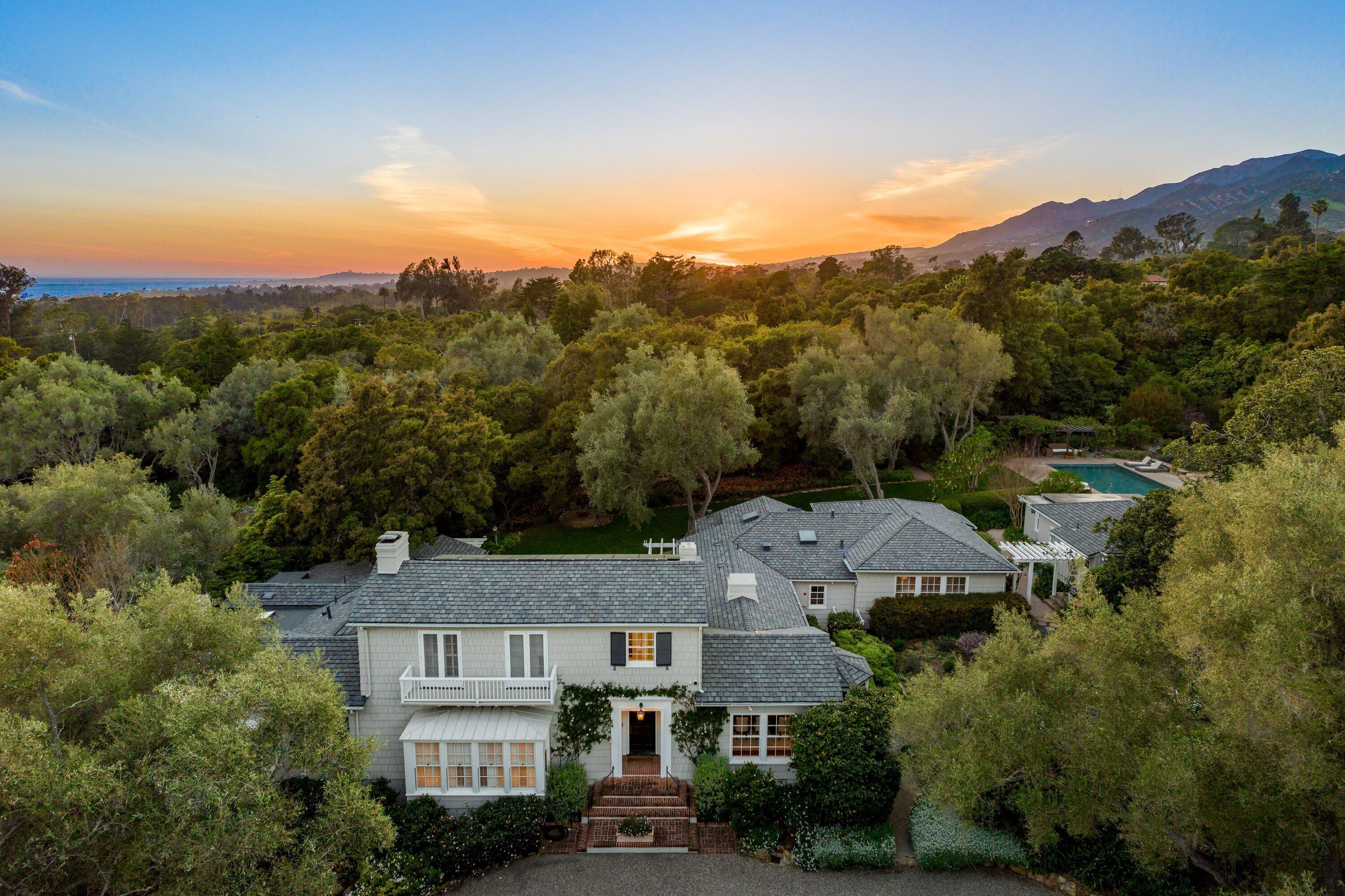 an aerial view of residential houses with outdoor space and trees