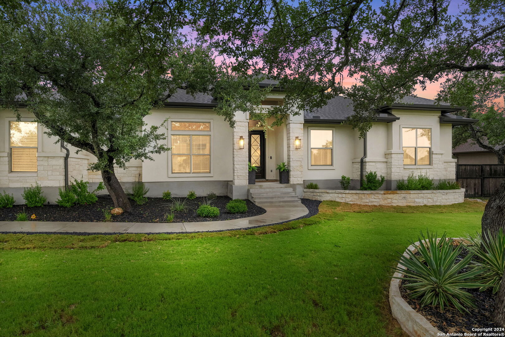 a front view of a house with a yard and potted plants