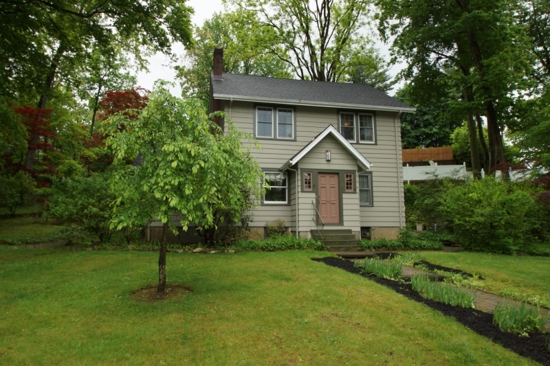 a front view of a house with a garden