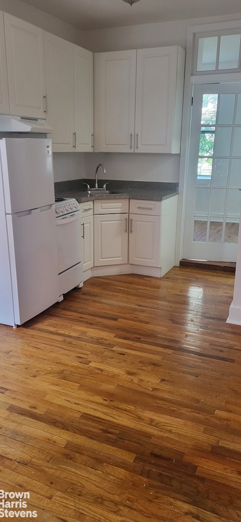 a view of a kitchen with stainless steel appliances granite countertop a sink and cabinets