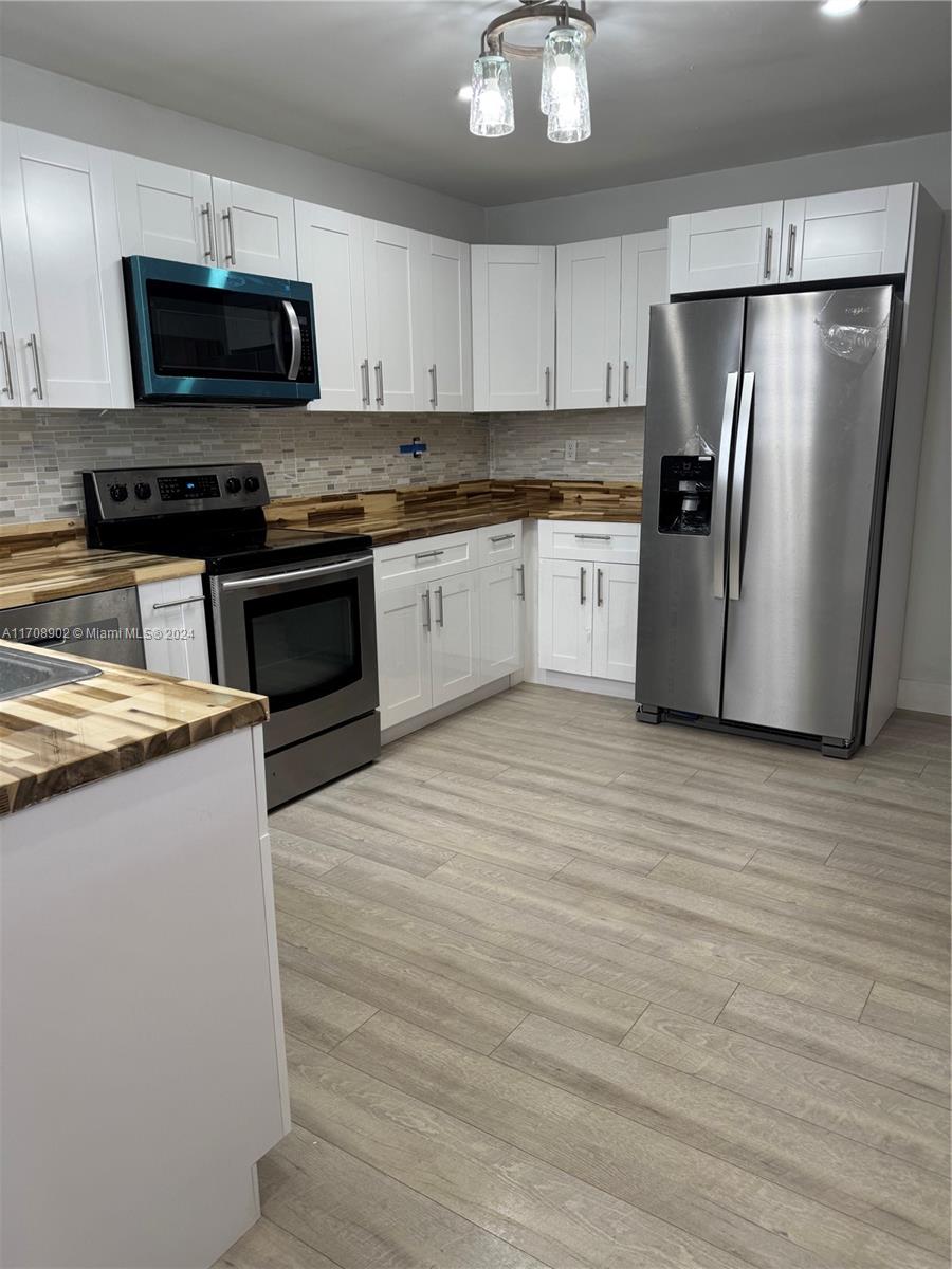 a kitchen with stainless steel appliances a refrigerator a stove a microwave and cabinets