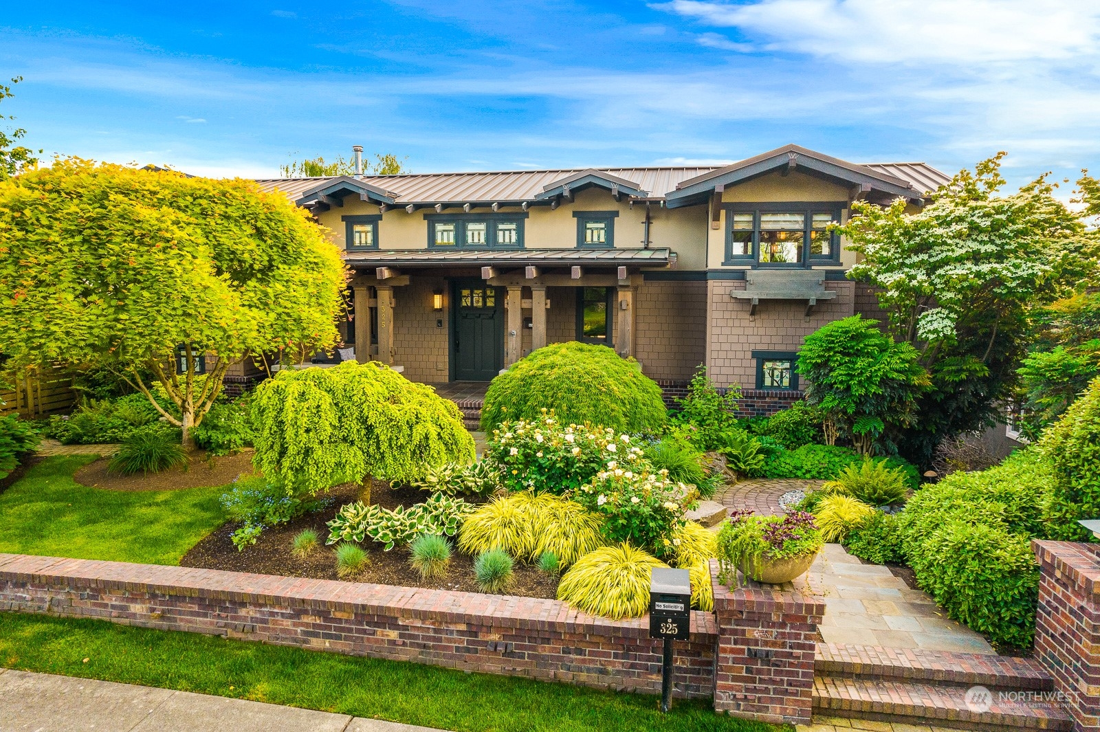 a front view of a house with a yard and potted plants