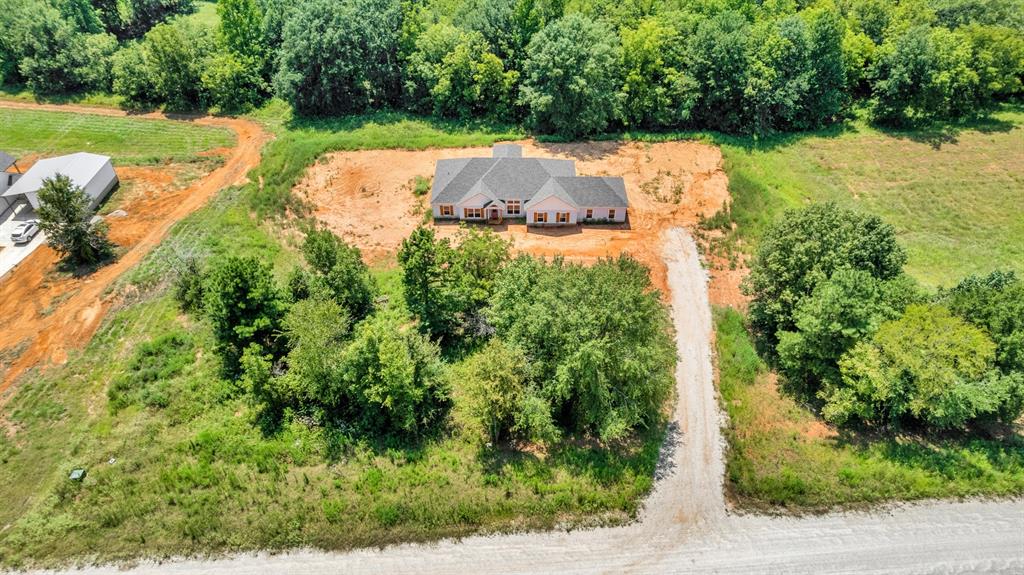 an aerial view of a house with a yard and lake view