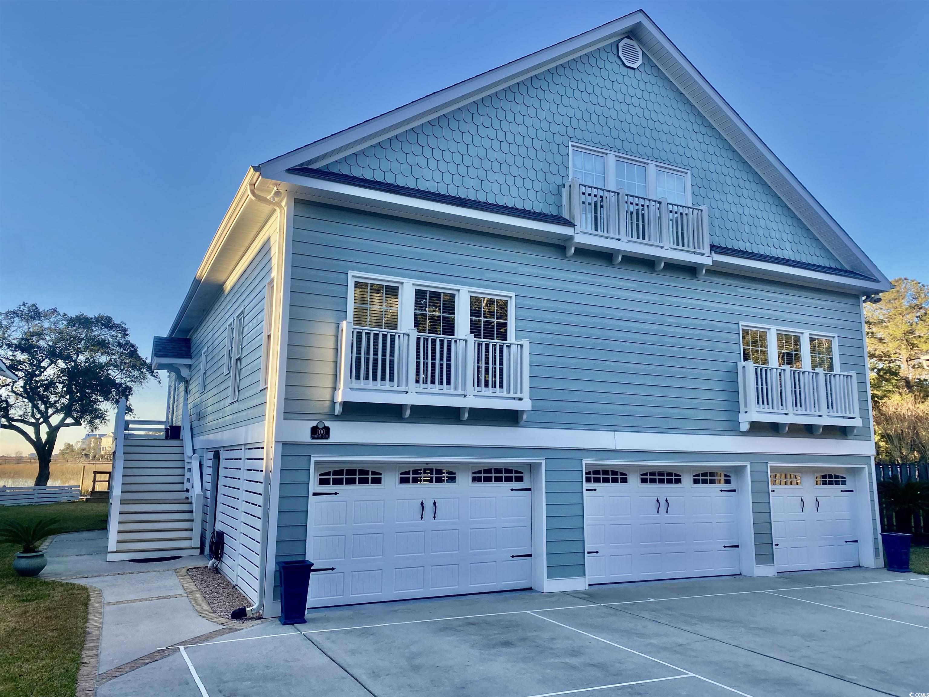 View of side of property with a garage and a balco