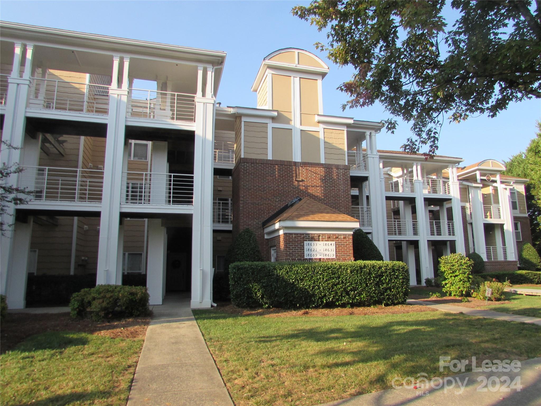 a front view of a residential apartment building with a yard